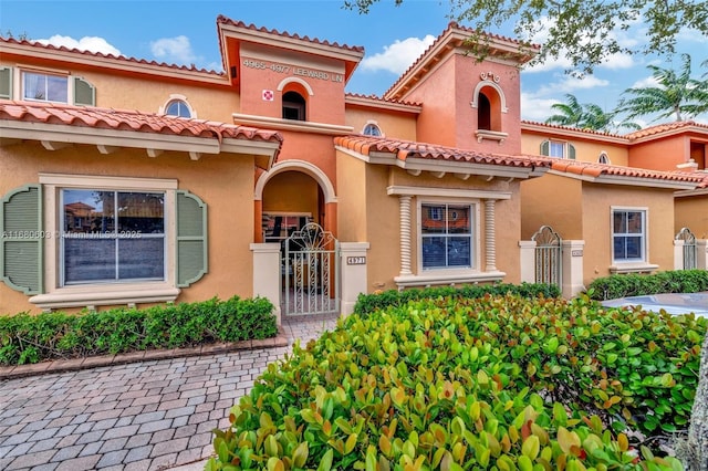 view of front of property with a gate, fence, and stucco siding