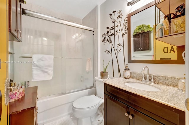 full bathroom with toilet, vanity, and bath / shower combo with glass door