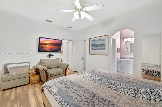 bedroom with ceiling fan, sink, ensuite bath, and light wood-type flooring