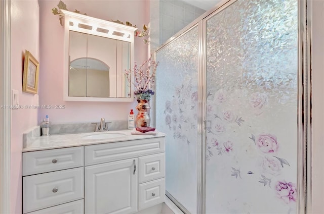 bathroom with a shower with shower door and vanity