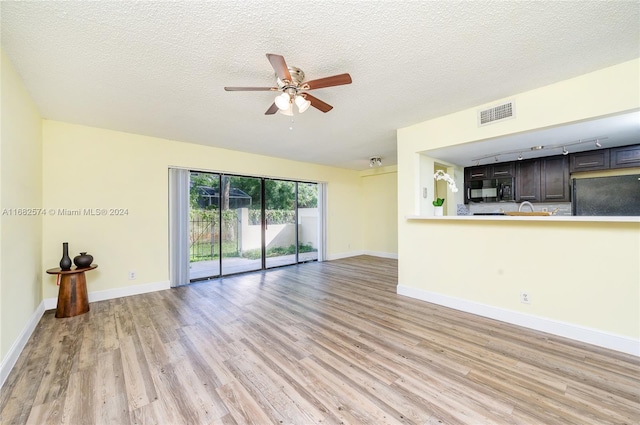 unfurnished living room with a textured ceiling, light hardwood / wood-style floors, and ceiling fan