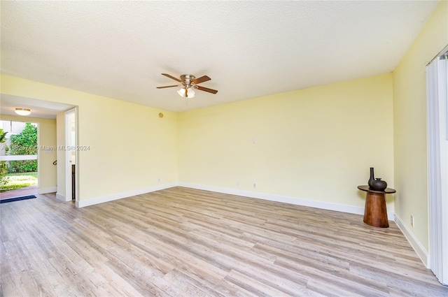 spare room featuring light hardwood / wood-style floors, a textured ceiling, and ceiling fan