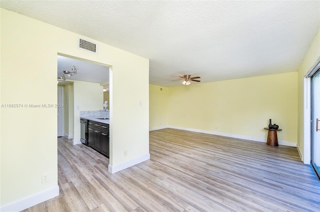 interior space featuring light hardwood / wood-style flooring, a textured ceiling, and ceiling fan