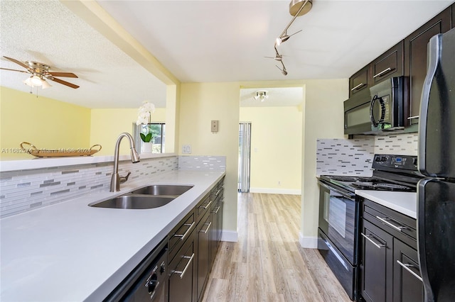 kitchen with black appliances, sink, light wood-type flooring, dark brown cabinets, and decorative backsplash