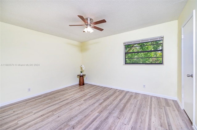 unfurnished room featuring a textured ceiling, light wood-type flooring, and ceiling fan