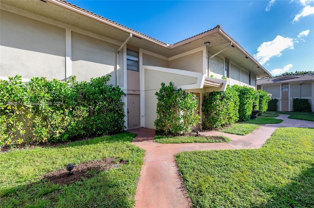 entrance to property with a lawn