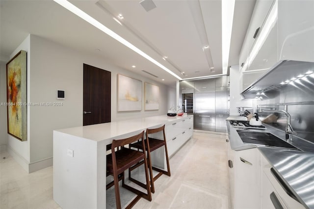 kitchen featuring white cabinetry, a center island, and sink