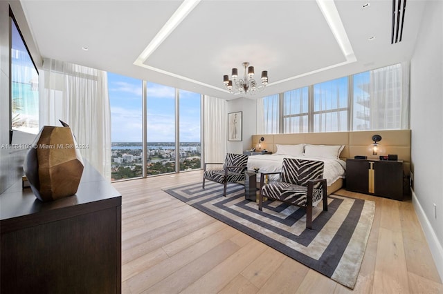 bedroom featuring light hardwood / wood-style floors, a notable chandelier, and floor to ceiling windows