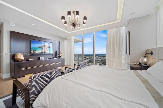 bedroom featuring light hardwood / wood-style floors, an inviting chandelier, and floor to ceiling windows