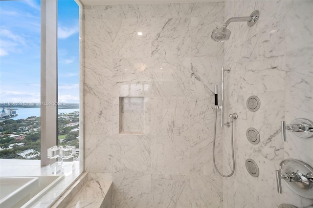 bathroom featuring independent shower and bath and a water view