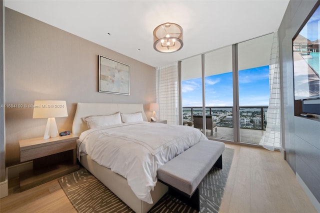 bedroom with floor to ceiling windows, access to outside, and light wood-type flooring