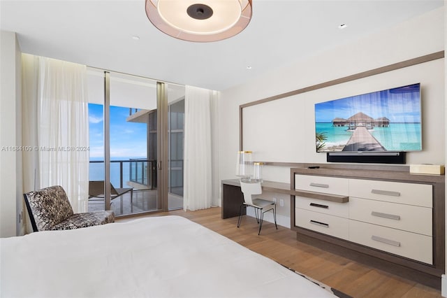 bedroom featuring light hardwood / wood-style flooring, access to exterior, and built in desk