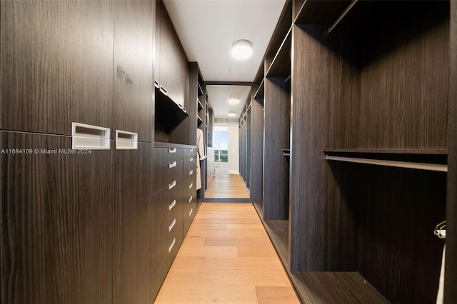 corridor with light hardwood / wood-style flooring and a mail area