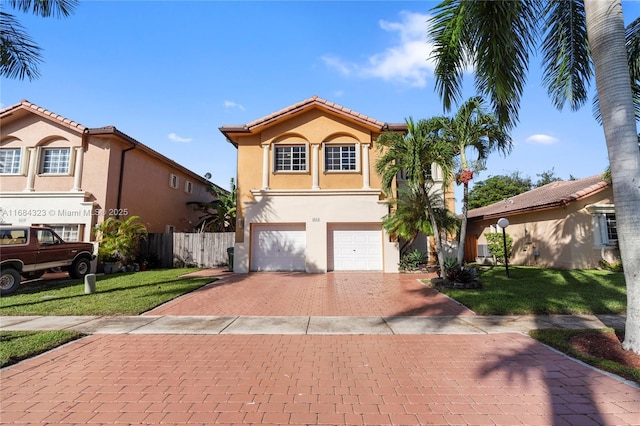 mediterranean / spanish-style house featuring a garage and a front lawn