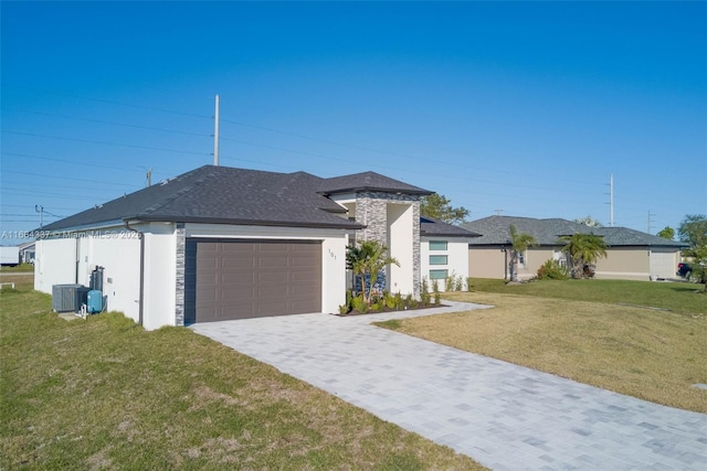 view of front facade featuring a front yard, a garage, and central AC unit