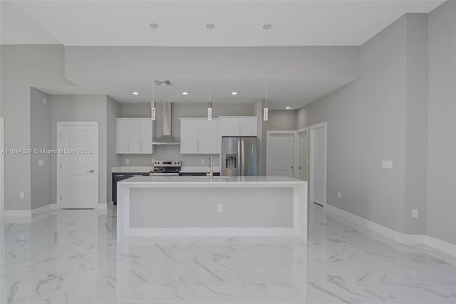 kitchen with white cabinets, stainless steel appliances, wall chimney exhaust hood, and an island with sink