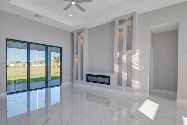 unfurnished living room with a raised ceiling and ceiling fan