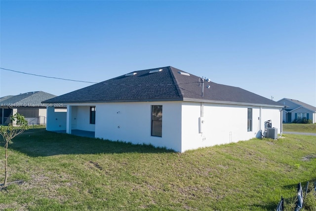 back of property featuring a yard and central AC