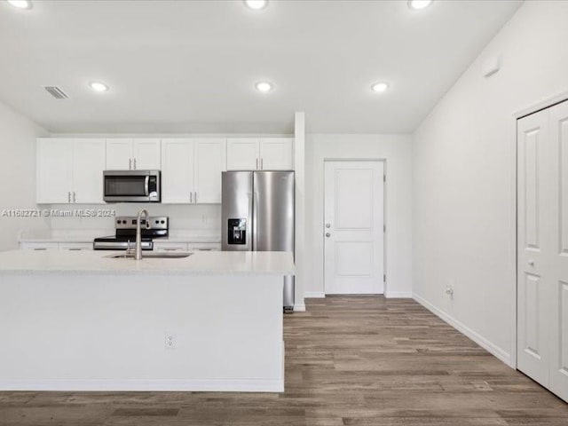 kitchen featuring sink, white cabinetry, stainless steel appliances, and light hardwood / wood-style floors