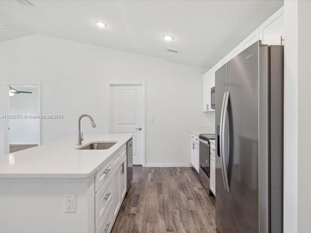 kitchen with lofted ceiling, white cabinets, stainless steel appliances, and sink