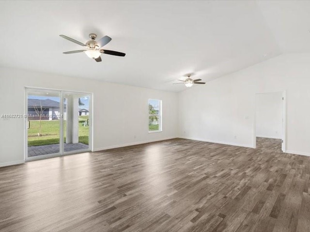 empty room with lofted ceiling, ceiling fan, plenty of natural light, and dark hardwood / wood-style flooring