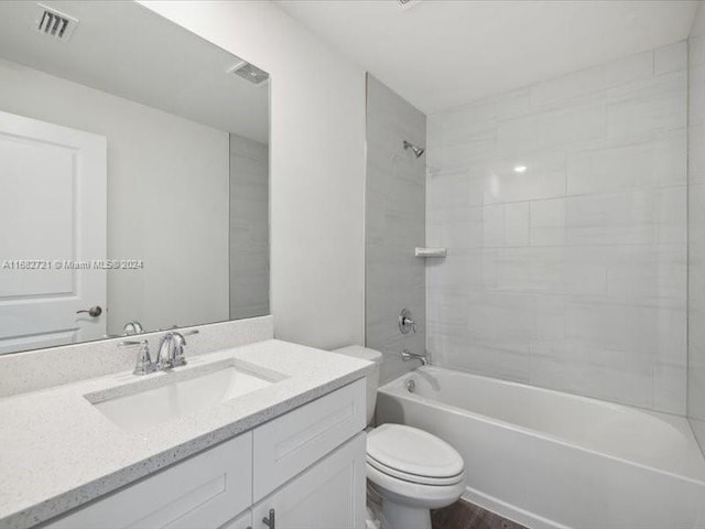 full bathroom featuring vanity, tiled shower / bath combo, and toilet