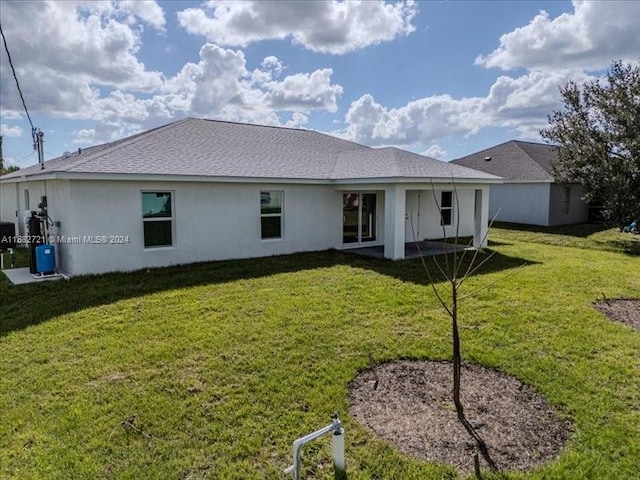 rear view of property featuring a lawn