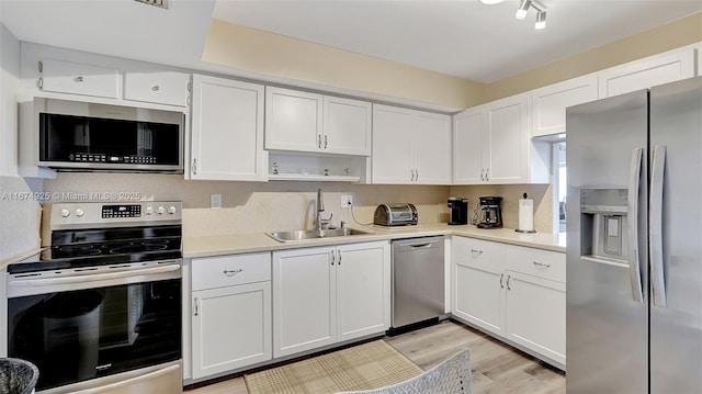 kitchen with white cabinets, stainless steel appliances, and a sink