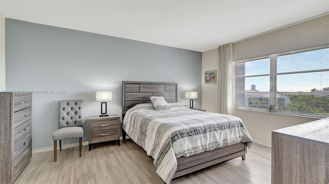 bedroom with light wood finished floors and baseboards