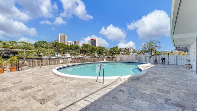 pool featuring a view of city, fence, and a patio