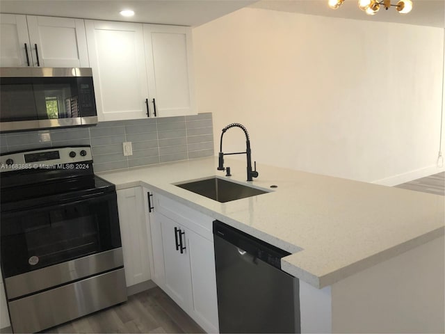 kitchen with white cabinets, sink, dark hardwood / wood-style floors, light stone counters, and stainless steel appliances