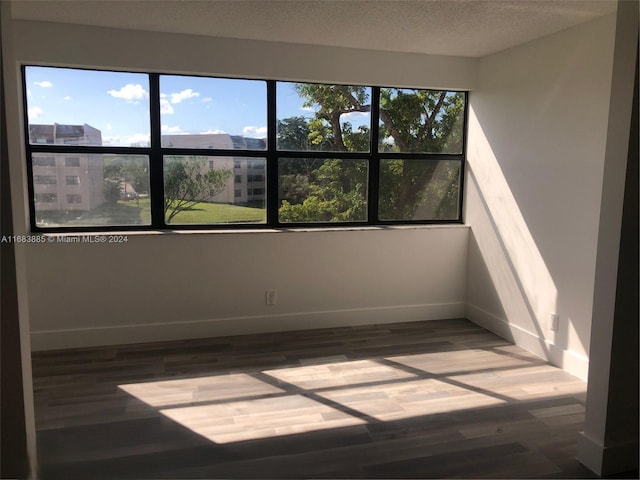 spare room with wood-type flooring and a textured ceiling