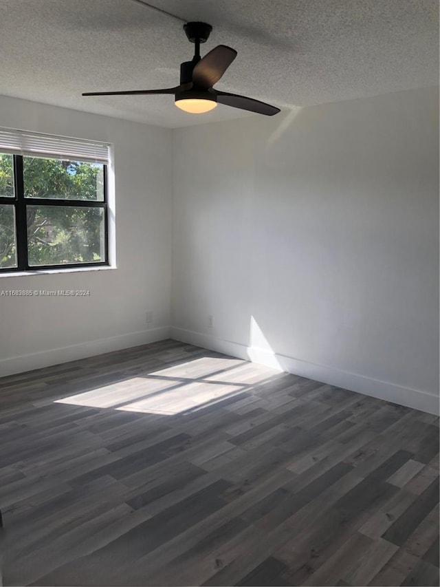 spare room with a textured ceiling, dark hardwood / wood-style floors, and ceiling fan