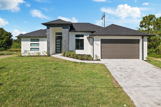 prairie-style home with a front yard and a garage