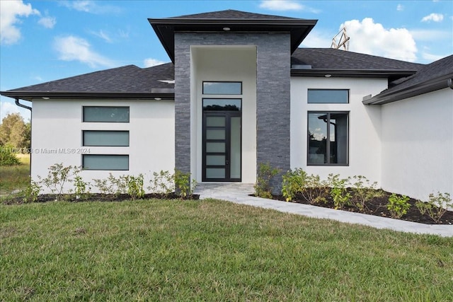 entrance to property with a lawn