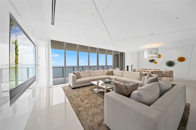 living room featuring a wall of windows, a notable chandelier, a water view, and light tile patterned floors