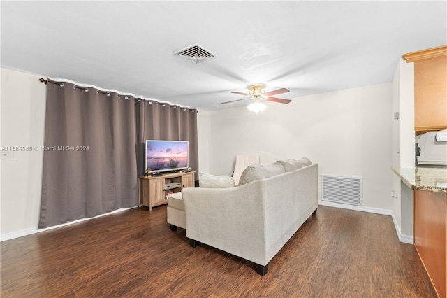 living room featuring ceiling fan and dark hardwood / wood-style flooring