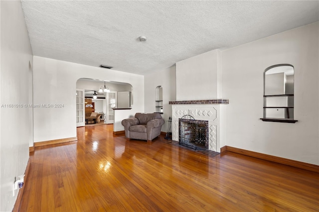 unfurnished living room featuring a textured ceiling and wood-type flooring