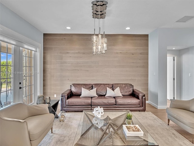 living room featuring french doors, wood walls, and light hardwood / wood-style flooring