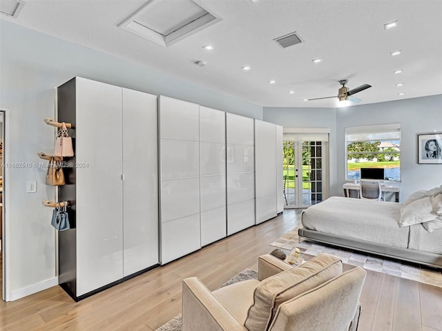 bedroom featuring light hardwood / wood-style flooring, a textured ceiling, access to exterior, and ceiling fan