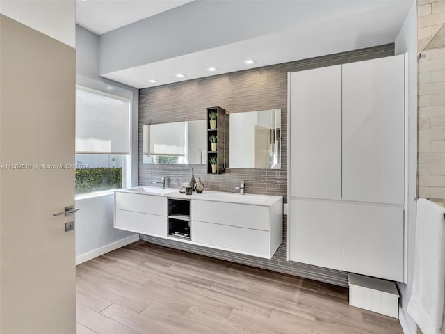 bathroom featuring vanity, decorative backsplash, and hardwood / wood-style floors