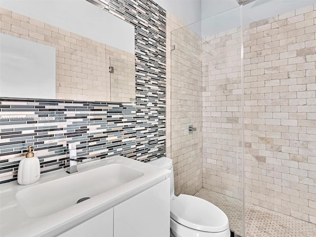 bathroom with vanity, toilet, walk in shower, and decorative backsplash