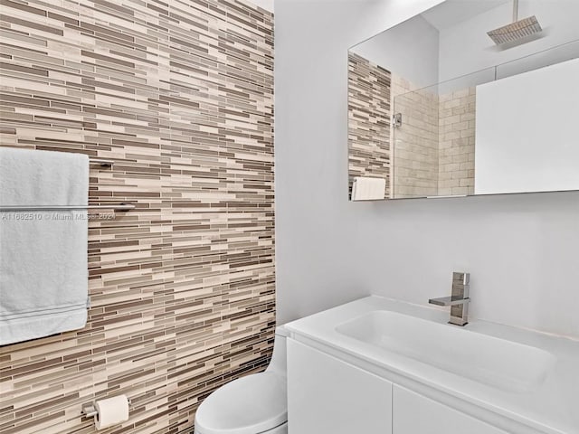 bathroom with vanity, a tile shower, and toilet