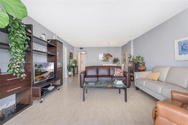 living room with a wall of windows and light tile patterned floors