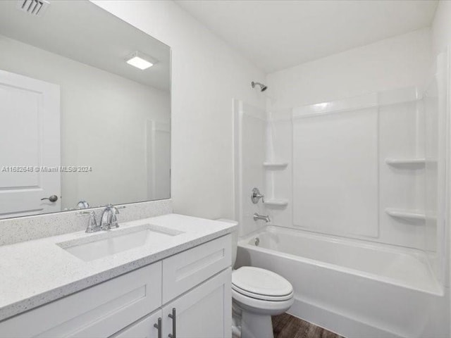 full bathroom with toilet, hardwood / wood-style flooring, vanity, and  shower combination