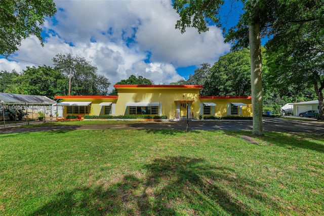 view of front of home with a front yard and a carport