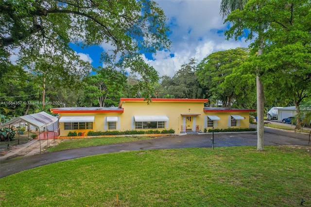 view of front of house with a carport and a front yard