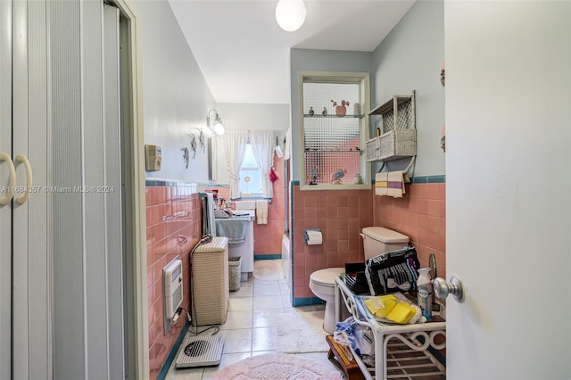 bathroom featuring toilet, tile patterned floors, and tile walls