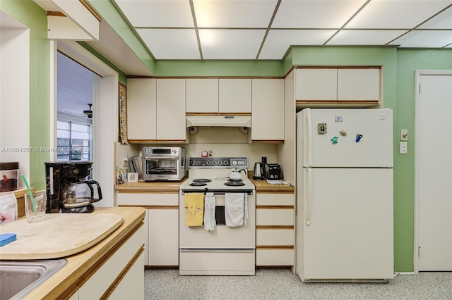 kitchen featuring white appliances, a paneled ceiling, and white cabinets