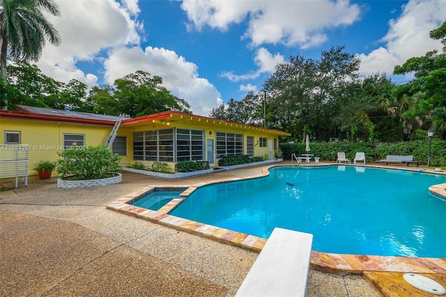 view of pool with a patio area and a diving board